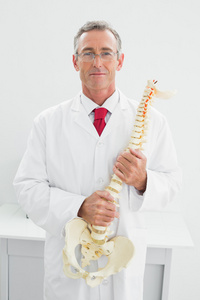 男医生在办公室举行的骨架模型