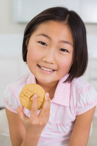 一个微笑的小女孩享受 cookie 的肖像