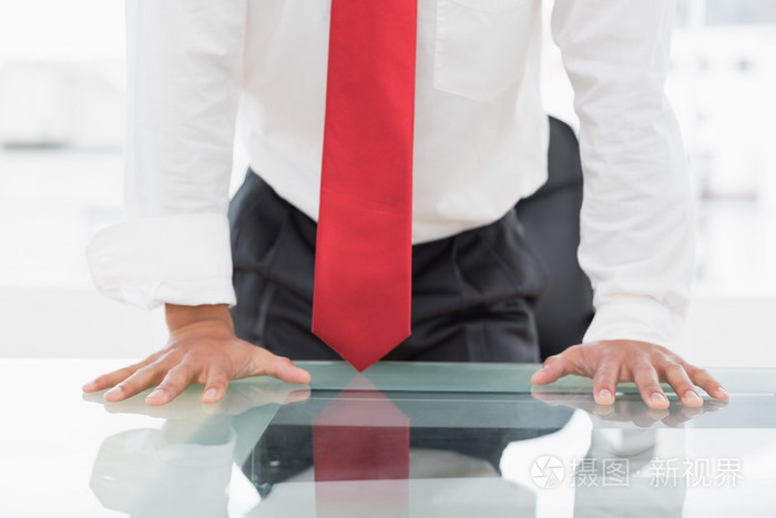 手放在桌子上的一名商人中段