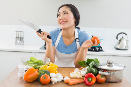 femme rflchie, hacher les lgumes dans la cuisine体贴的女子切菜在厨房里