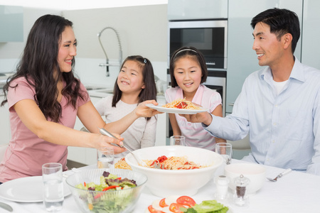 幸福的女人提供家庭在厨房中的食物