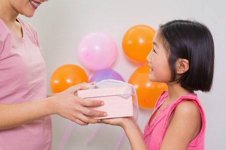 礼品盒给一个小女孩在生日聚会上的女人