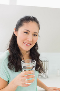 一个女人用一杯水在厨房里的特写镜头