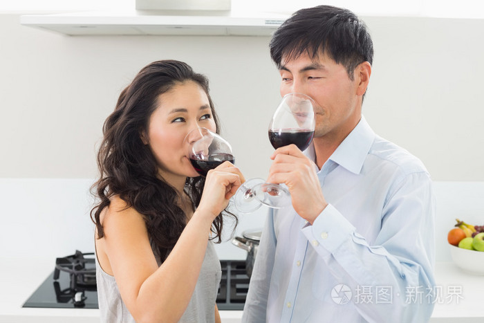 恩爱的小夫妻在厨房里喝红酒