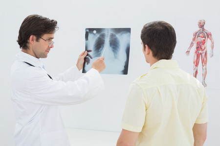 男医生向病人解释脊柱 x 射线