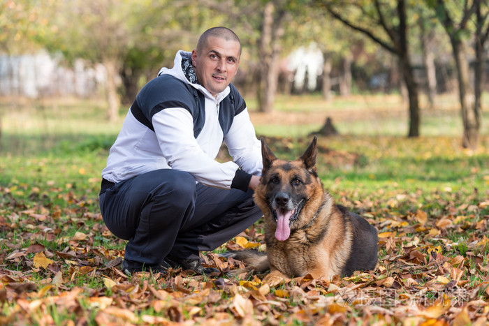 男人抱着狗德国牧羊犬