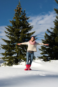 漂亮的女孩在雪山上跳跃的照片