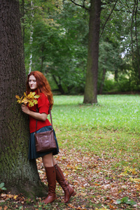 时尚女人走在秋天的公园