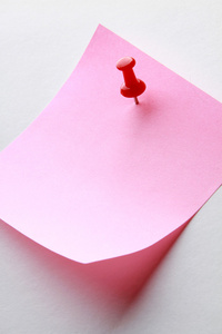 粉红色的备忘录便条上记着一个红色的别针