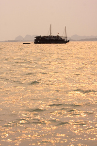 传统的越南木制小船航行在龙湾在日落时分，越南，东南亚