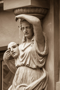 一个女人与戏剧面具的雕像