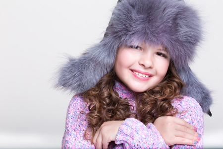 可爱的小女孩，在冬季皮毛帽子和多彩舒适毛衣