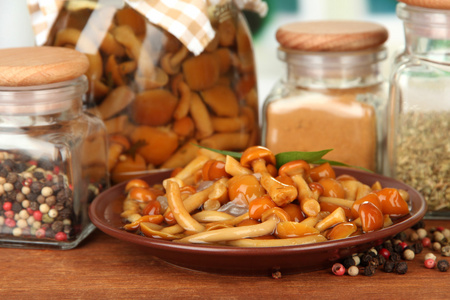 美味的组成腌制蘑菇 油和香料在明亮的背景上的木桌上