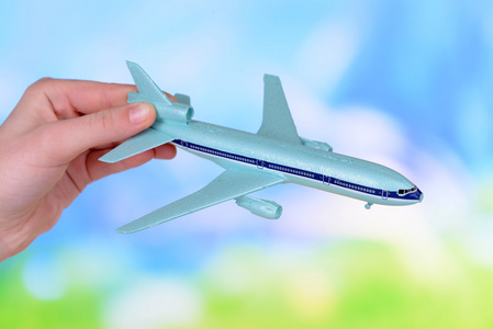 玩具飞机在浅蓝色背景上的手