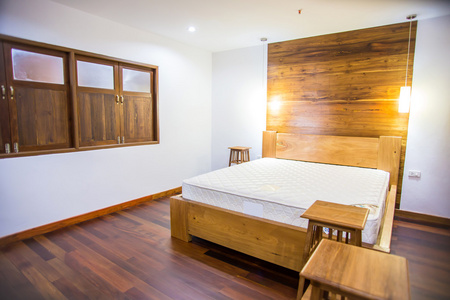 卧室的内部，与白色的床上用品和硬木地板
