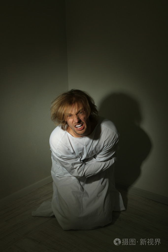 精神病在房间角落里的海峡夹克的男子