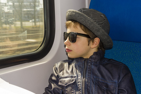 太阳镜的英俊男孩骑上一列火车图片