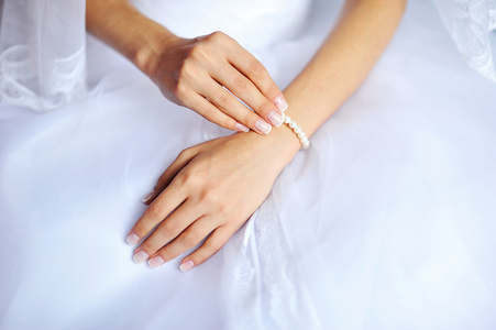 指甲上的白色婚纱的新娘的手图片