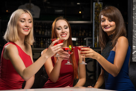 三个女孩举着酒杯在一家夜总会