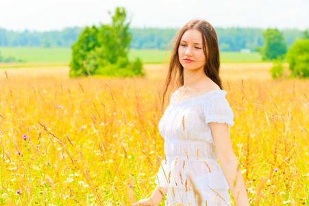 在黄色的花田的年轻女子