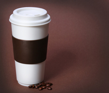 咖啡杯上棕色背景的咖啡豆。外卖或迪