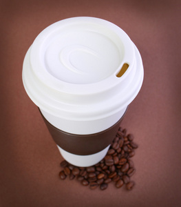 咖啡杯上棕色背景的咖啡豆。外卖或迪
