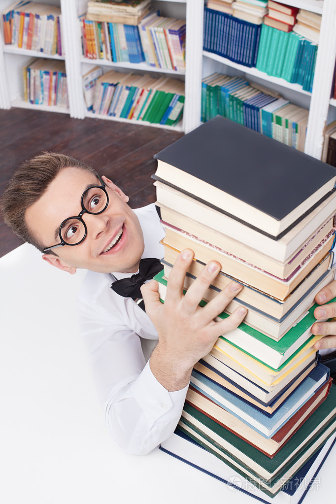 年轻的书呆子男人拥抱书库