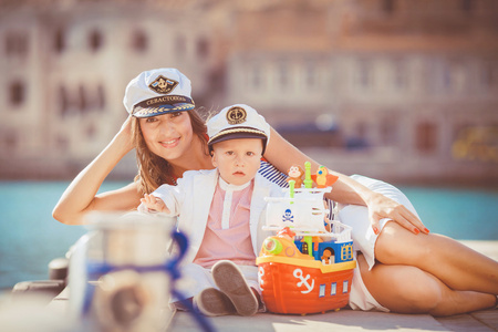 一个母亲带着她的儿子玩在海中有城，静物照片由码头上的肖像
