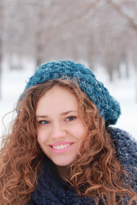 在蓝色贝雷帽微笑户外在冬季的一天在公园里的漂亮女孩