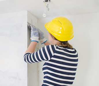 女性的泥水匠修理用油灰糊墙照片