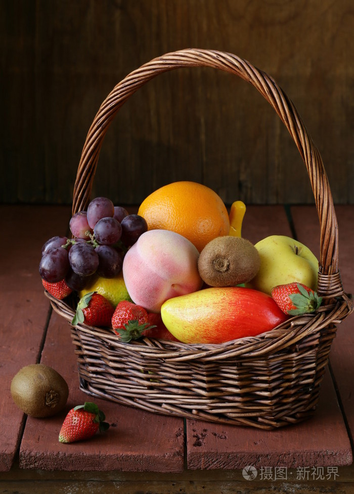 与在一张小木桌上的水果静物柳条编织的篮子