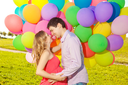 年轻健康的美丽孕妇与她的丈夫和气球