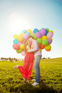 年轻健康的美丽孕妇与她的丈夫和气球