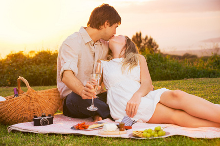 对夫妇享受浪漫日落野餐