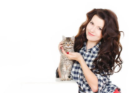 一个年轻的漂亮女人，牵着她只可爱的小猫，孤立的白色背景上的肖像