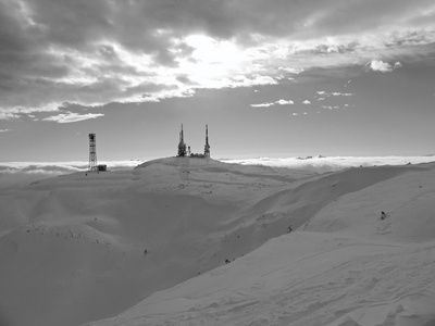 在滑雪胜地山的顶峰从低雾都突出来了