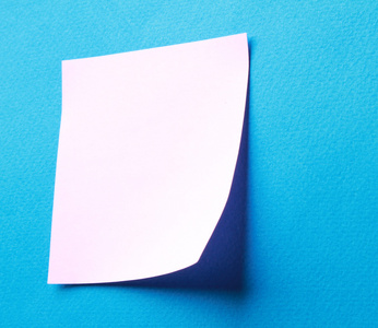 孤立的蓝色背景上的粉红色的纸注意