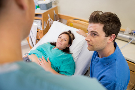 男人和怀孕的女人听护士在医院里