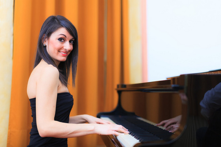 面带笑容的女人弹钢琴