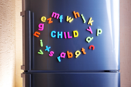 词的孩子拼写冰箱上使用彩色磁性字母