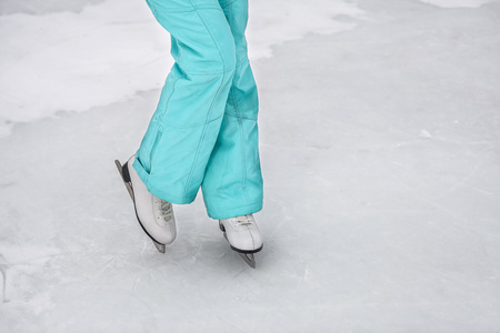 年轻的姑娘在冰冻的湖面上滑冰