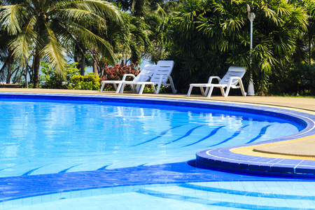 豪华游泳池和日光浴白关在热带花园