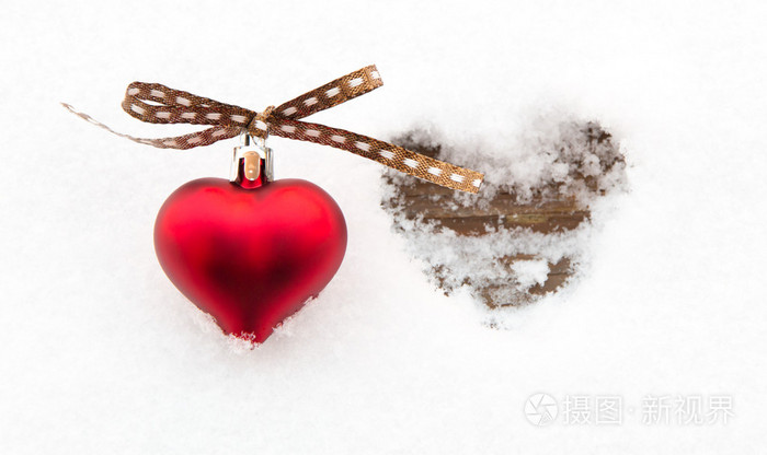 红色的心融化的心形状的旁边的雪地上