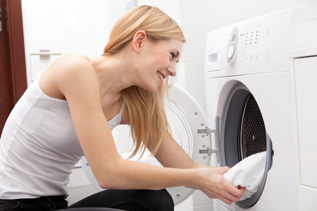 年轻漂亮的女人，用一台洗衣机