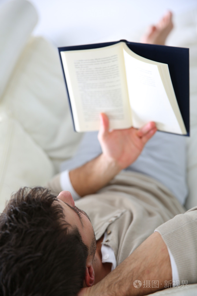 躺在沙发上看书的人
