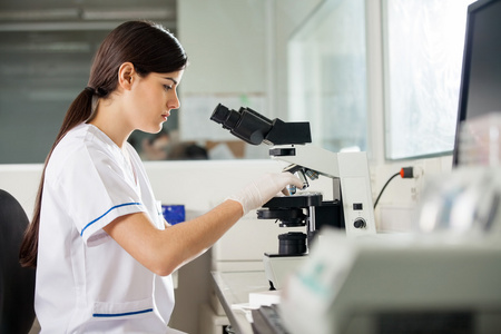女科学家在实验室里用显微镜