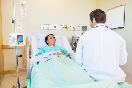 成熟的病人看着医生躺在医院的床上