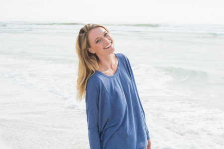 一个微笑的随便的女人在海滩的肖像