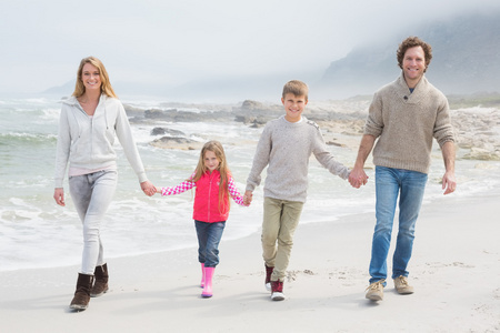 幸福的家庭，四手挽手漫步在海滩上