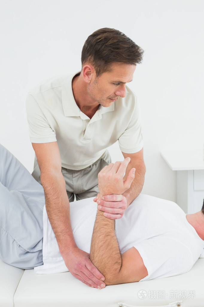 男性理疗师检查一个人的手